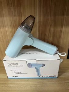 Foldable sky blue handheld steamer with HB-668 packaging on dark wood surface