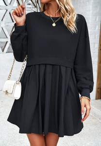 Détail d'une robe élégante à manches longues avec jupe plissée noire de haute qualité