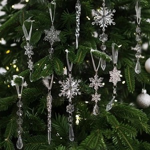 Clear crystal-like icicle and snowflake ornaments set hanging on a green Christmas tree