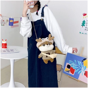 Plush Shiba Inu crossbody bag with golden chain strap worn by model in home setting