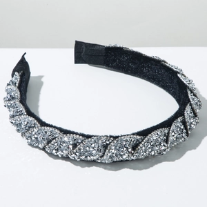 Dettaglio del cerchietto in velluto nero intrecciato con strass argentati brillanti