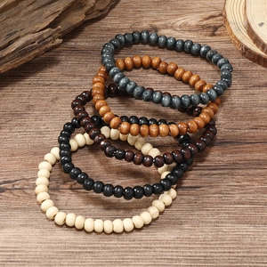 Detail of multi-colored wooden beads bracelets in grey, brown, black and ivory tones