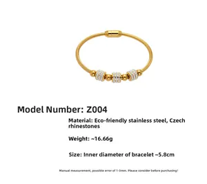 Gros plan sur un bracelet serpent doré en acier inoxydable avec trois perles en cristal