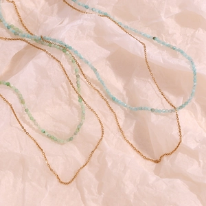 Close-up of dual-layer 18K gold-plated chain with turquoise amazonite beads on pink background