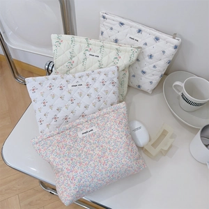 Detailed close-up of quilted floral cotton makeup bags with simple wish branding