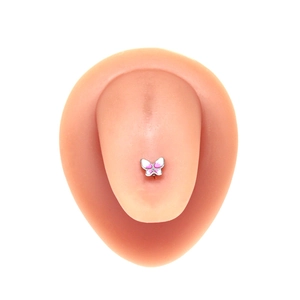 Detail view of a pink and white butterfly tongue ring on a silicone model tongue