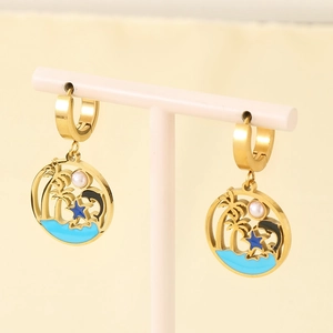 Detailed shot of gold dolphin and palm tree beach earrings with blue enamel and pearls
