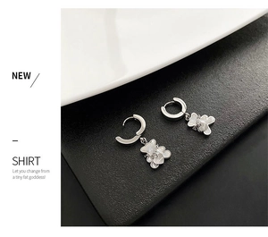 Detail of silver bear earring with mother of pearl inlay and engraved love heart charm