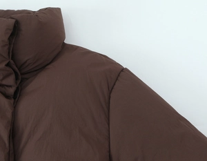 Detailed view of the dark brown padded jacket collar showing fabric texture and seams