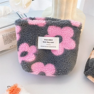 Gray plush square pouch with pink flower design and white fabric label for storage