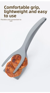 Macro detail of a 2-in-1 kitchen spatula tong flipping cooked meat on white background