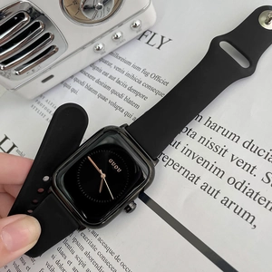 Minimalist black square watch with silicone strap and gold-tone hands on a white background