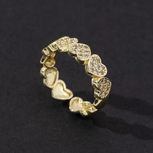 Macro detail of gold-plated open ring featuring pavé zircon heart charms and adjustable band
