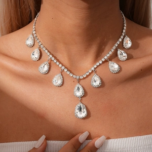 Gros plan d'un collier argenté avec pendentifs en forme de goutte en cristal brillant