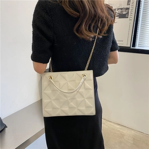 Detail of off-white quilted crossbody bag with dual straps and elegant chain hardware