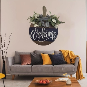 Close-up of wooden welcome door sign with faux greenery and black-white bow in a living room