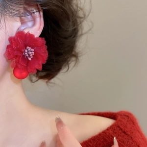 Close-up of red fabric flower earrings with crystal beads and elegant tassel detail