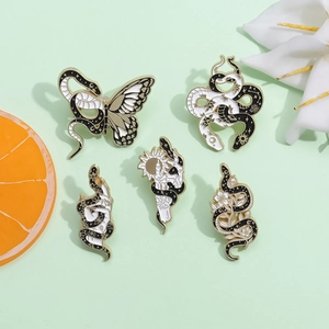 Set of 5 dark style enamel pins with snake butterfly and sun motifs on green background