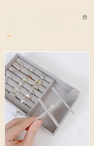 Close-up of gray velvet jewelry box featuring adjustable dividers and ring storage