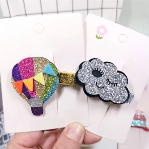 Close-up of glittery rainbow hot air balloon and smiling cloud hair clips for children