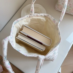 Close-up of pink floral quilted cotton handbag showing spacious interior for books