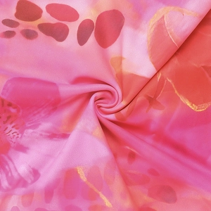 Gros plan détaillé du tissu imprimé floral rose et orange avec texture plissée centrale