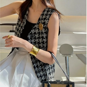 Minimalist wide gold curved cuff bracelet styled with black and white tweed vest