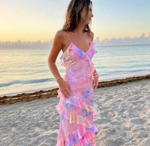 Détail de l'ourlet à volants sur une robe longue en mousseline à fleurs au coucher du soleil