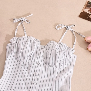 Detail of striped sundress featuring bow-tie straps and button-down front pleated bodice