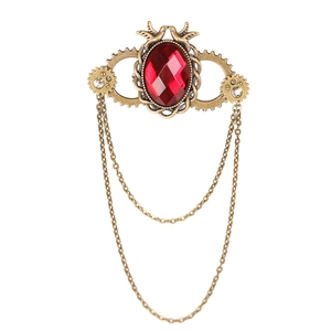 Steampunk gear wing brooch with deep red gemstone and brass chains on white background