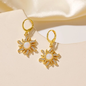Close-up of golden sunflower earrings with opal center and micro-pave zircons