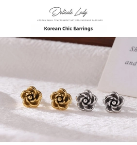 Detailed view of floral titanium steel stud earrings in gold and silver finishes