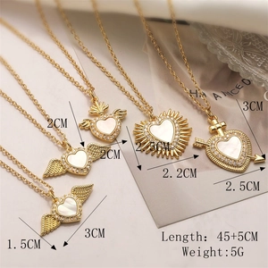 Detailed view of gold plated heart pendants with shell inlay and cubic zirconia stones