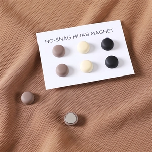 Set of 8 no-snag hijab magnetic pins in matte beige and black on brown fabric
