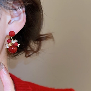 Macro detail of red zircon cluster earrings with gold plating on model profile
