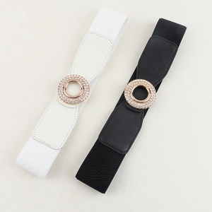 Close-up of black and white elastic waist belts with sparkling rhinestone round buckles