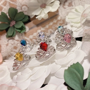 Macro shot of 18K gold plated crown rings with colorful pear-cut gemstones on flowers