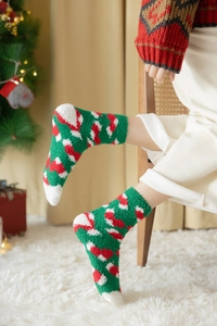 Detail von flauschigen Weihnachtssocken aus Korallenfleece in grün-rotem Muster