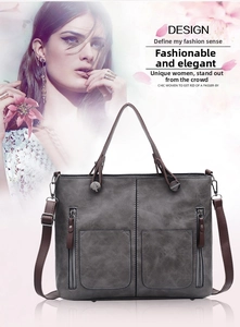 Detail of vintage gray textured faux leather handbag with symmetric zip pockets and strap