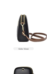 Close-up of contrast crossbody bag with gold zippers and premium stitching details