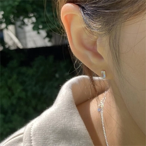 925 sterling silver square gemstone stud earrings worn by a model in outdoor setting