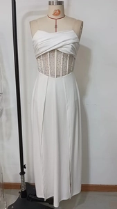 Detail of white evening dress featuring rhinestone corset waist and mesh fishbone bodice