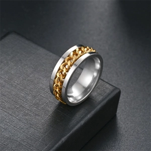 Macro shot of silver titanium steel ring with a golden chain inlay and bottle opener design