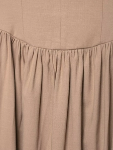 Macro detail of khaki cotton linen dress featuring pleated texture and curved stitching