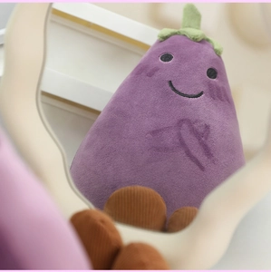 Mirror reflection showing a cute purple plush eggplant pendant with embroidered smiling face
