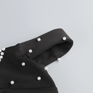 Vue détaillée du tissu noir orné de perles élégantes pour un effet sophistiqué