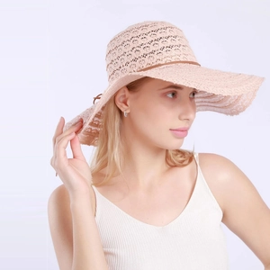 Detail of elegant pink lace sun hat with wide wavy brim and brown leather band