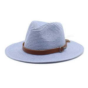 Detail of light blue woven Panama hat with brown leather band and silver buckle