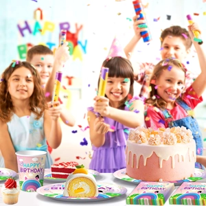 Close-up of Gabby's Dollhouse themed party paper cups, plates and napkins on a table