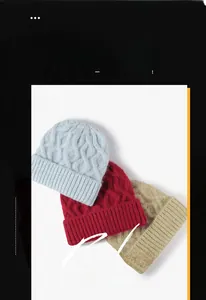 Detail of chunky knit beanies in light blue, burgundy, and khaki with thick spiral patterns